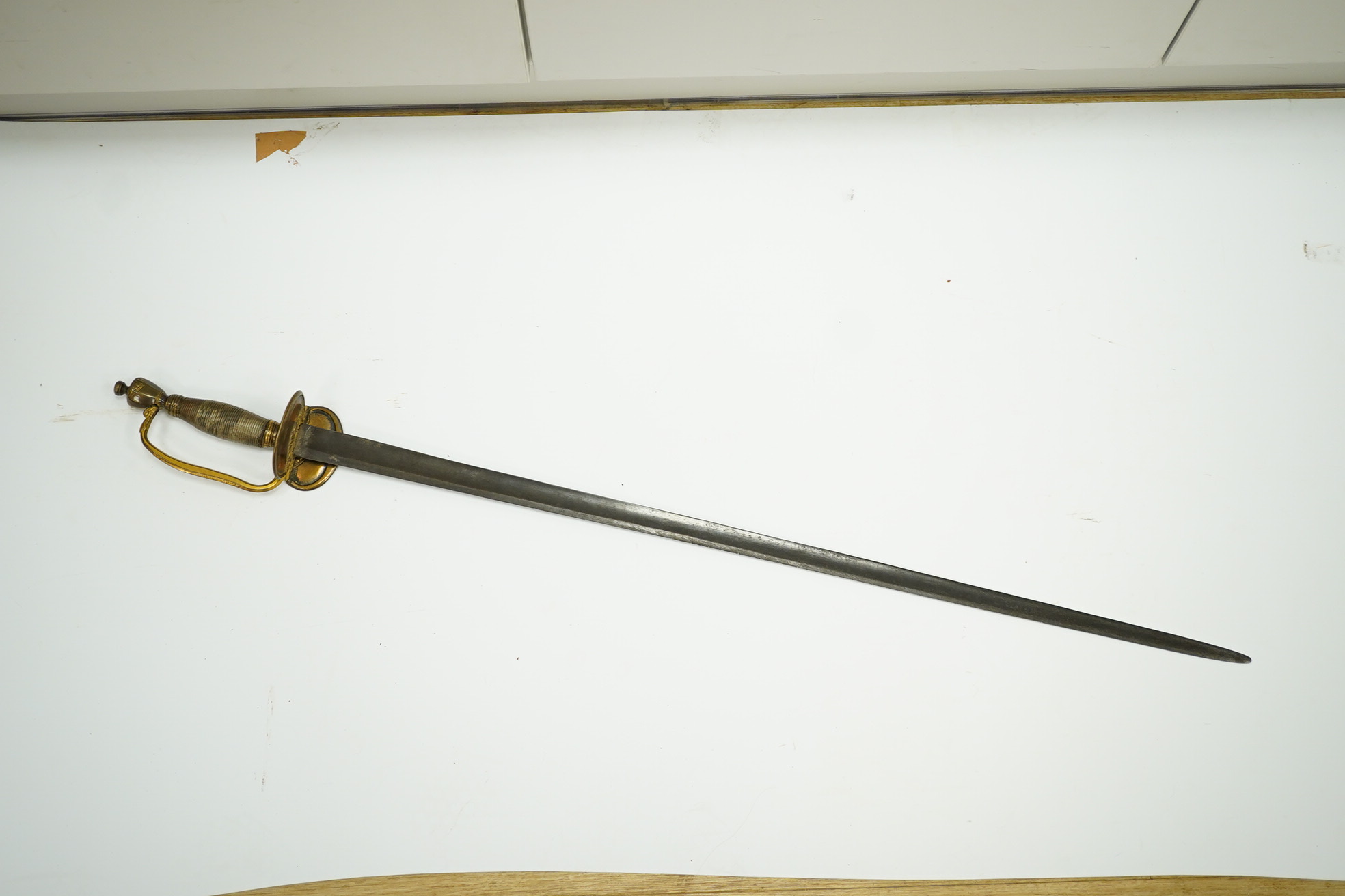 A 1796 pattern infantry officer's sword with regulation single edge blade, hilt with traces of gilding. Condition - fair, grip covering and quillon incomplete.